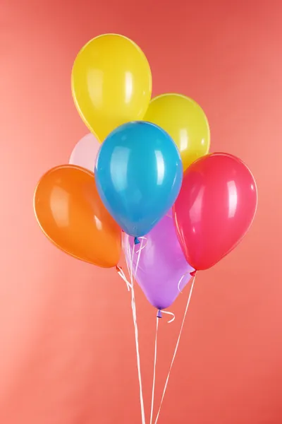 Bunte Luftballons auf rotem Hintergrund — Stockfoto