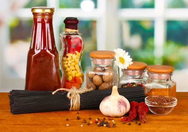 Esparguete de massas, legumes e especiarias na mesa de madeira no fundo brilhante — Fotografia de Stock