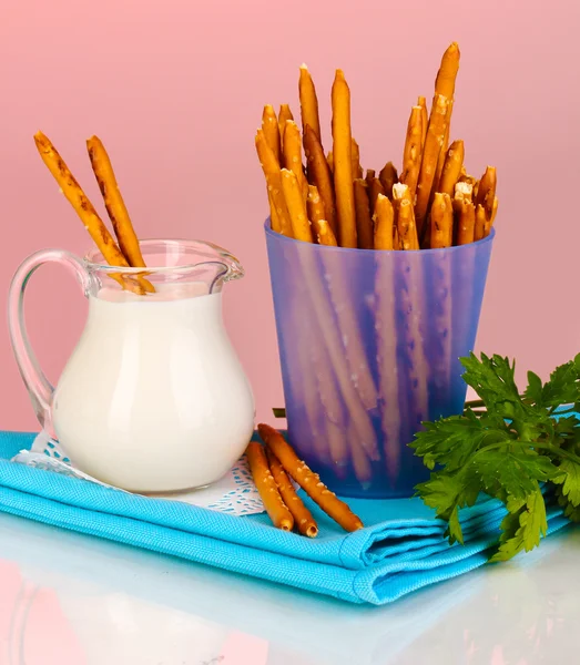 Palitos crocantes saborosos em copo de plástico roxo no fundo vermelho — Fotografia de Stock