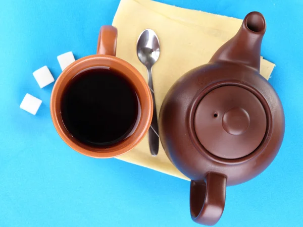 Top view of cup of tea and teapot on blue tablecloths — Stock Photo, Image