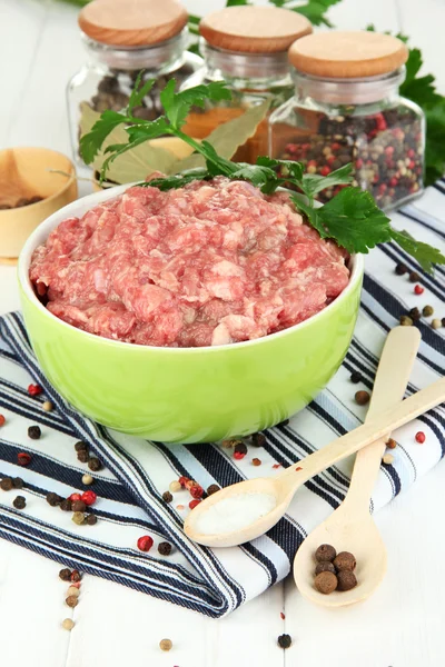Bowl of raw ground meat with spices on wooden table — Stock Photo, Image