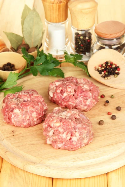 Raw meatballs with spices on wooden table — Stock Photo, Image