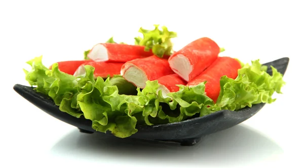 Krabbenstangen mit Salatblättern und Zitrone auf Teller isoliert auf weiß — Stockfoto