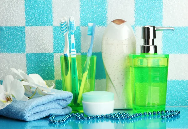 Accesorios de baño en el estante en el baño sobre fondo de pared de azulejo azul —  Fotos de Stock