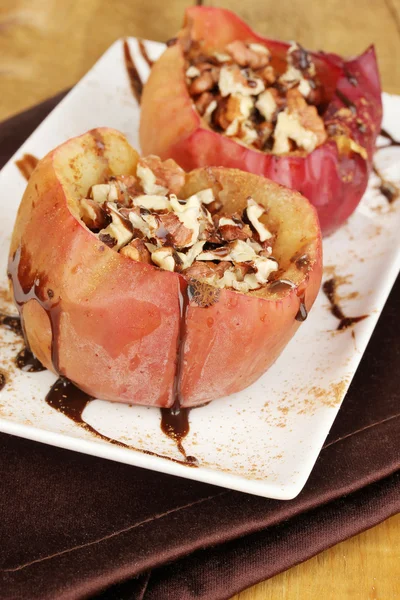 Запеченные яблоки на тарелке на деревянном столе — стоковое фото
