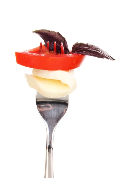 Tasty mozzarella with tomatoes on fork isolated on white — Stock Photo, Image