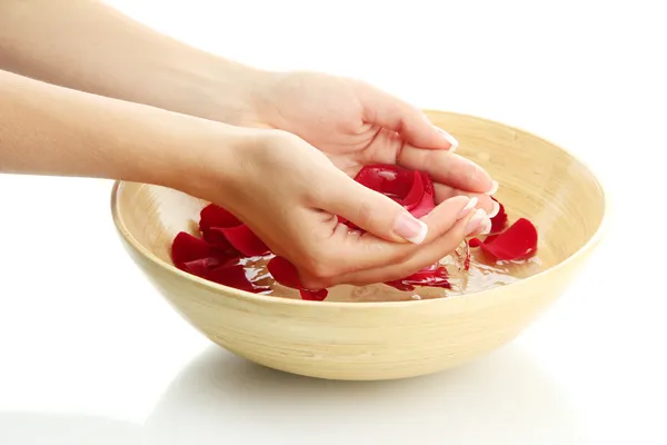 Manos de mujer con cuenco de madera de agua con pétalos, aislado en blanco — Foto de Stock