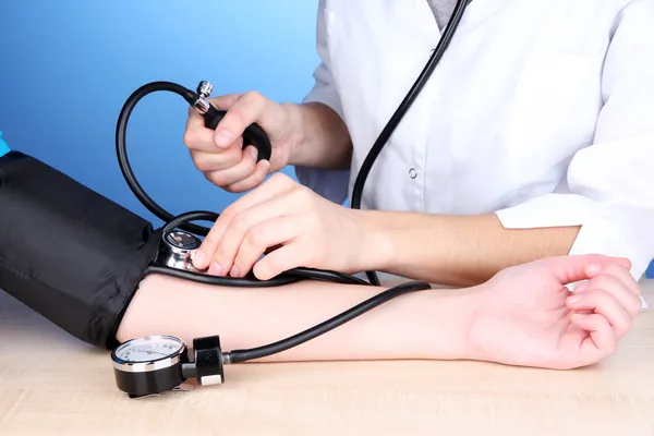 Medición de la presión arterial sobre fondo azul — Foto de Stock