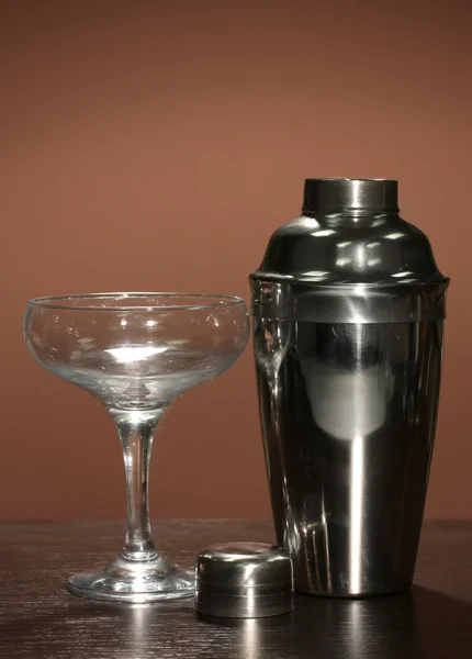 Cocktail shaker and cocktail glass on color background — Stock Photo, Image