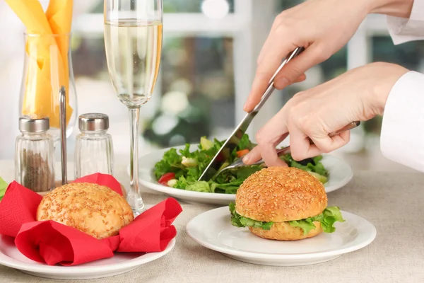 Vrouwelijke hand met diner op lichte achtergrond — Stockfoto