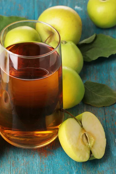 Užitečné Jablečná šťáva s kolem jablek na dřevěný stůl — Stock fotografie