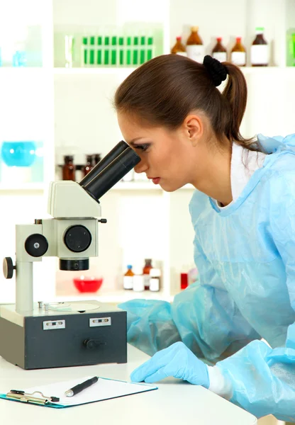 Junge Wissenschaftlerin schaut im Labor ins Mikroskop — Stockfoto