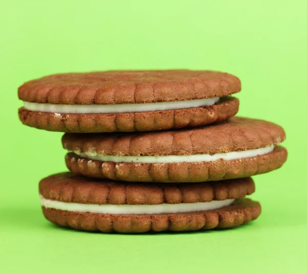 Yeşil zemin üzerine krem tabakası ile çikolatalı kurabiye — Stok fotoğraf