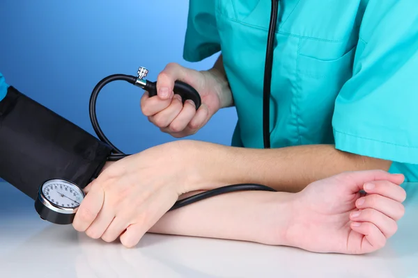 Blood pressure measuring on blue background Stock Photo