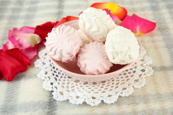 Marshmallows su piastra di colore su sfondo chiaro — Foto Stock