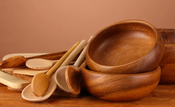 Drewniane naczynia na stole na brązowym tle — Zdjęcie stockowe