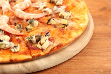 ahşap arka plan üzerinde durmak üstünde deniz ürünleri ile lezzetli pizza