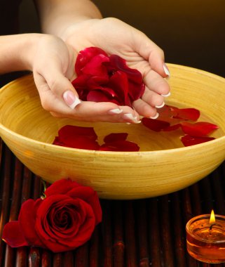 kadın eliyle su yaprakları kahverengi zemin üzerine ahşap kase