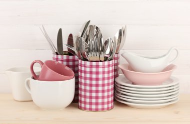 Cups, bowls nd other utensils in metal containers isolated on light background