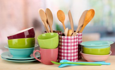 Cups, bowls nd other utensils in metal containers isolated on light background