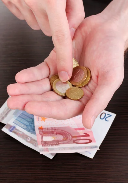 Tellen van geld in de hand op houten tafel achtergrond — Stockfoto