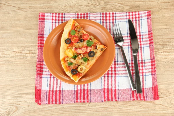 Prato com uma fatia de pizza deliciosa no fundo de madeira — Fotografia de Stock