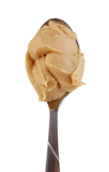 Deliciosa manteiga de amendoim na colher isolada em close-up branco — Fotografia de Stock