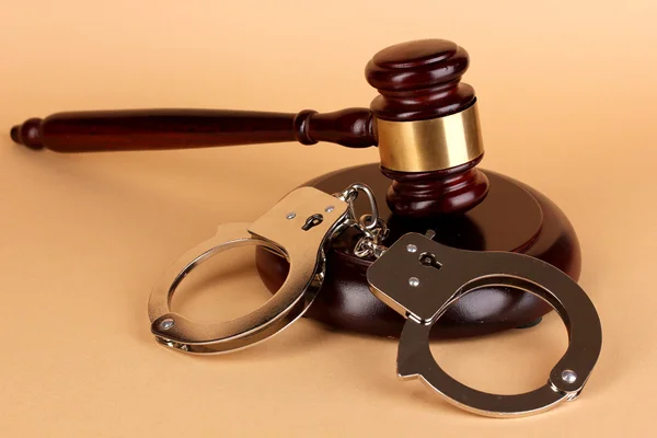 Gavel and handcuffs on beige background — Stock Photo, Image