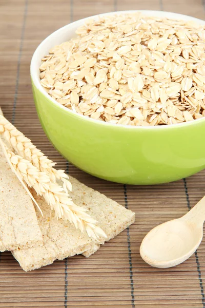 Grüne Schüssel voller Haferflocken mit Holzlöffel — Stockfoto