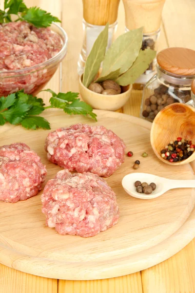 Raw meatballs with spices on wooden table — Stock Photo, Image