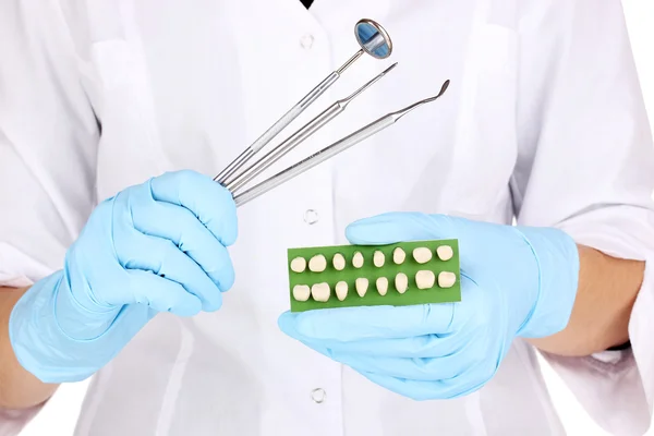 Dentistas manos en guantes médicos azules con herramientas dentales y prótesis dentales —  Fotos de Stock