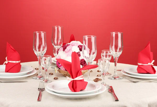 Table setting in red tones on color background — Stock Photo, Image