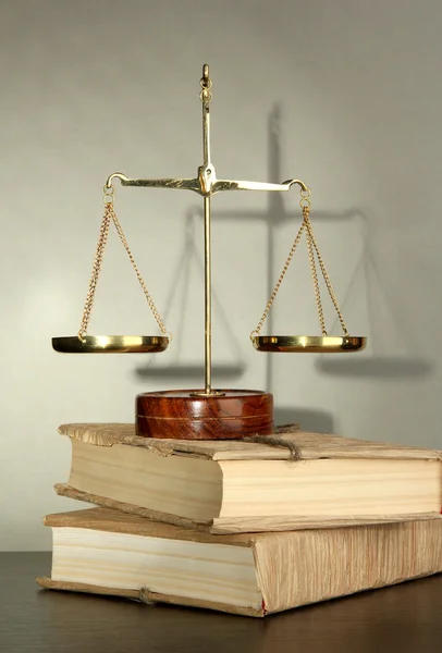 Gold scales of justice and books on grey background — Stock Photo, Image