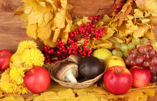 Composición otoñal con hojas amarillas, manzanas y setas sobre fondo de madera — Foto de Stock