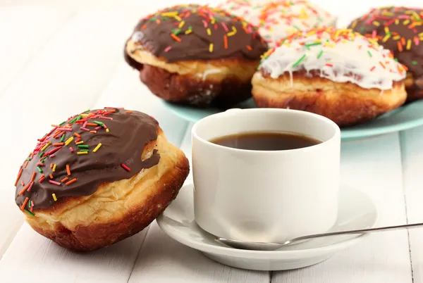 Tasty donuts on color plate on light wooden background — Stock Photo, Image