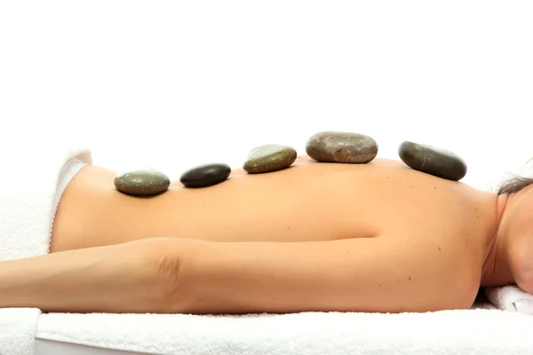 Schöne junge Frau im Wellness-Salon mit Wellness-Steinen, isoliert auf weiß — Stockfoto