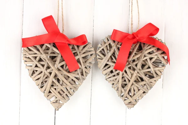 Wicker hearts with red bow on wooden background — Stock Photo, Image