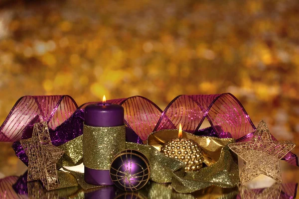 Composición navideña con velas y decoraciones en colores púrpura y dorado — Foto de Stock