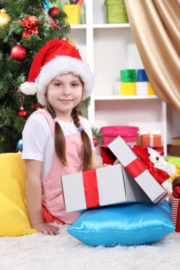 küçük bir kız bir hediye festively bir şekilde dekore edilmiş Oda açılır.