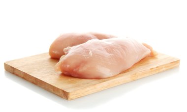 çiğ tavuk eti üzerinde beyaz izole kesme tahtası üzerinde