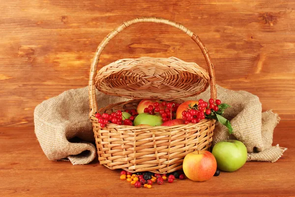 Raccolto di bacche e frutta in un cesto su sfondo di legno primo piano — Foto Stock