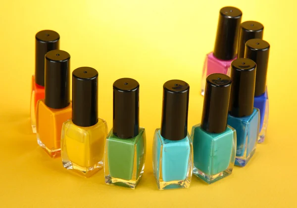 Groep van heldere nagel poetsmiddelen, op gele achtergrond — Stockfoto
