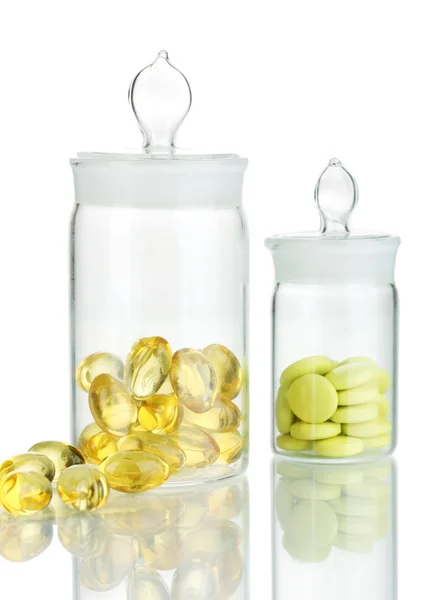 Cápsulas y pastillas en recipientes aislados en blanco —  Fotos de Stock