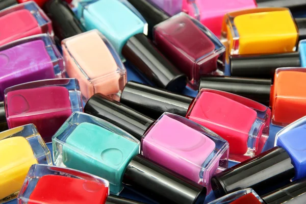 Group of bright nail polishes, on blue background — Stock Photo, Image