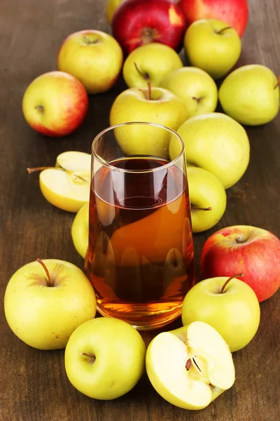 Useful apple juice with apples around on wooden table — Stock Photo, Image