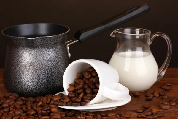 Kaffeemaschine mit Milch und weißer Tasse auf Holztisch — Stockfoto