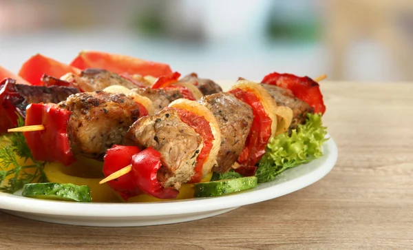 Sabrosa carne a la parrilla y verduras en pincho en el plato, en la mesa de madera — Foto de Stock