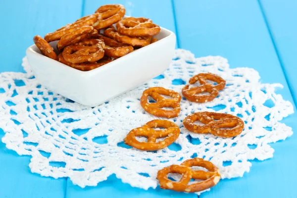 Pretzels saborosos em tigela branca em mesa de madeira close-up — Fotografia de Stock