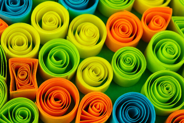 Colorful quilling on blue background close-up