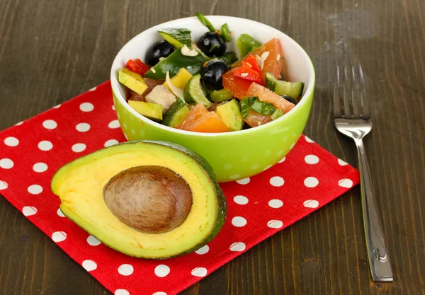 Sabrosa ensalada de aguacate en tazón sobre mesa de madera de cerca —  Fotos de Stock